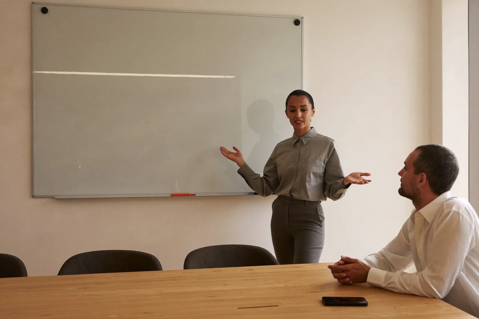 A specialist explaining at a whiteboard while a colleague listens